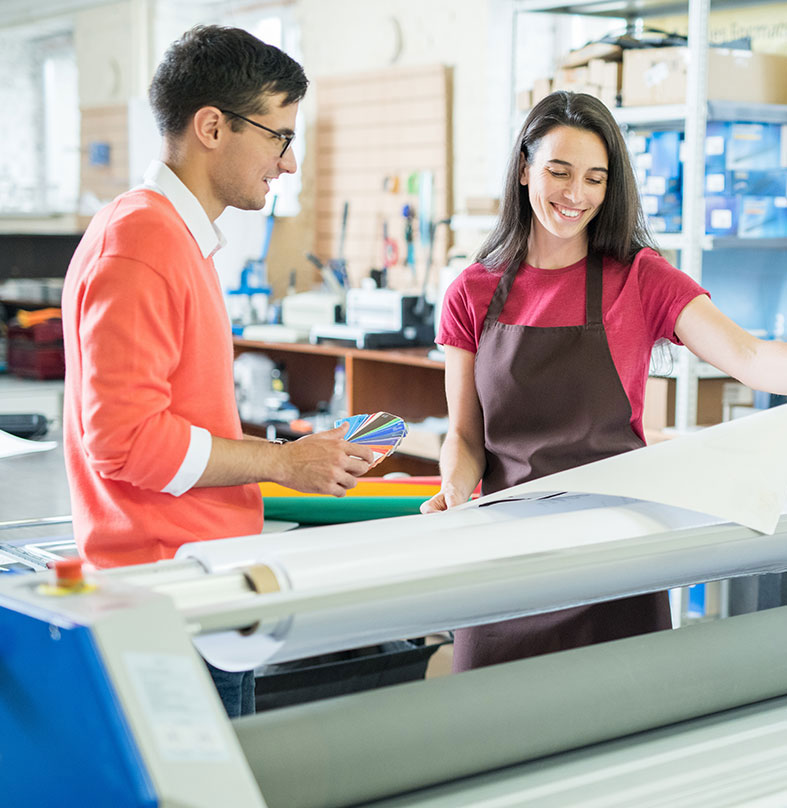Two print shop employees review a print
